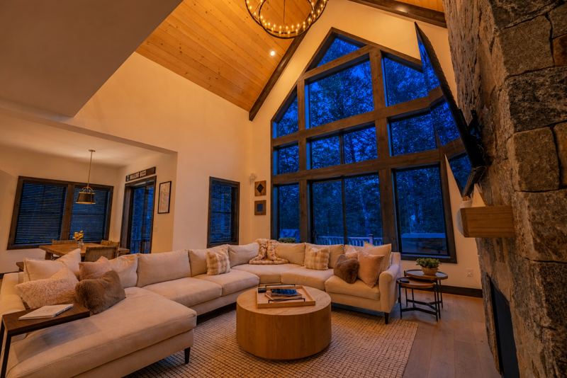 Great room with vaulted ceiling, stone fireplace and wall of windows
